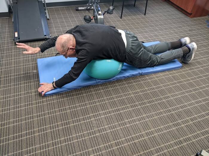 A patient working on core and balance using a stability ball during recovery.
